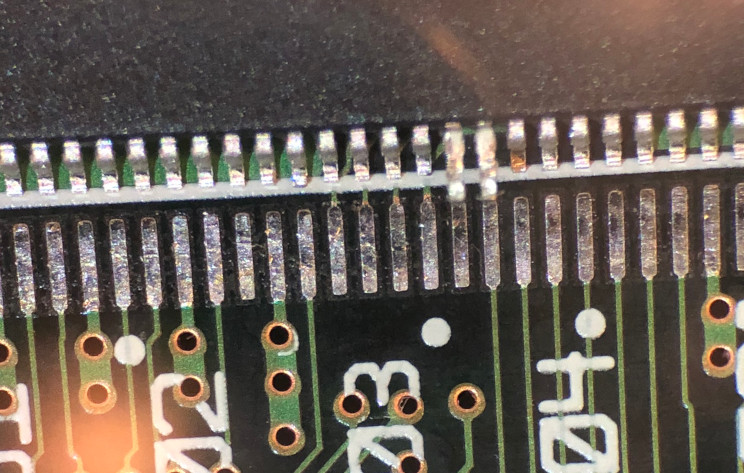 Photo through microscope of an SDRAM chip with pins 21 and 22
lifted
