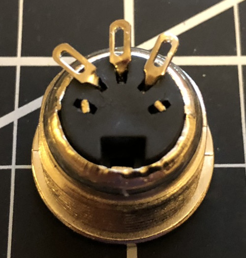 The back of a MIDI connector with the two outer pins clipped and the three inner pins bent up