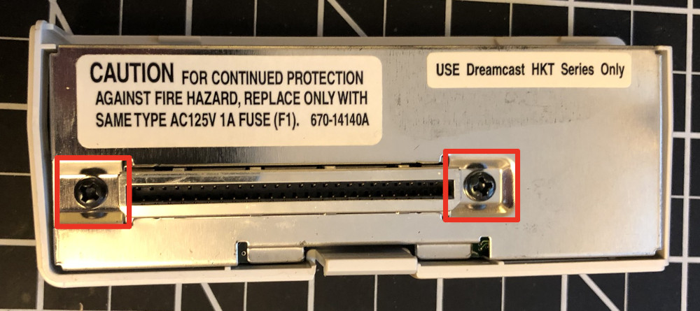 Bottom of Dreamcast modem with screws highlighted in red
