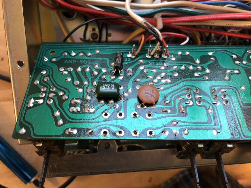 A photo of the bottom of the receiver's Flat Amplifier Assembly with three capacitors soldered to it